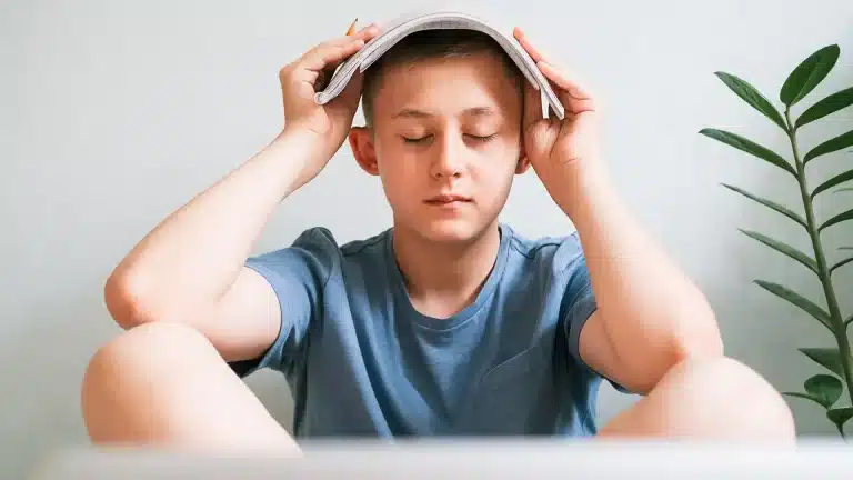 hypnosis, hypnotherapy, health A boy sitting on the floor with his head on his laptop.