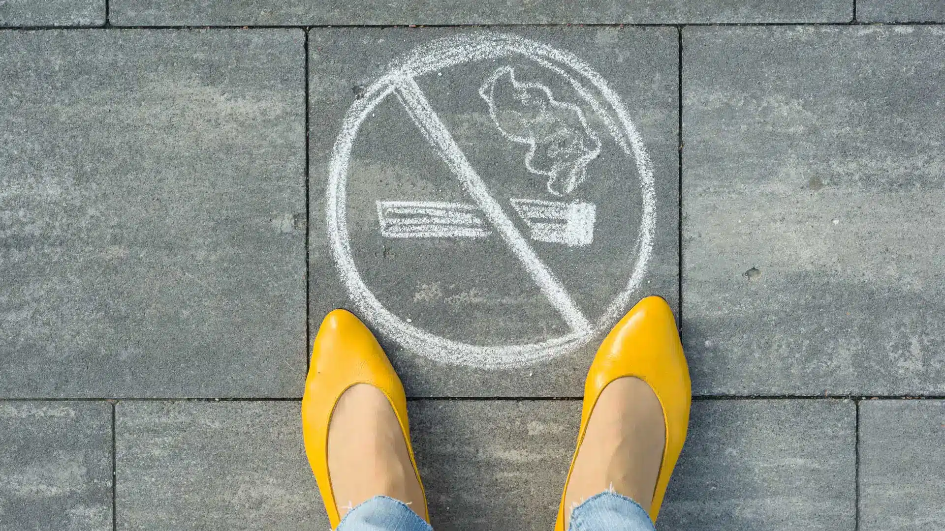 hypnosis, hypnotherapy, health A woman in yellow shoes is standing next to a no smoking sign.