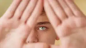 hypnosis, hypnotherapy, health A young man is holding his hands up in front of his eyes.