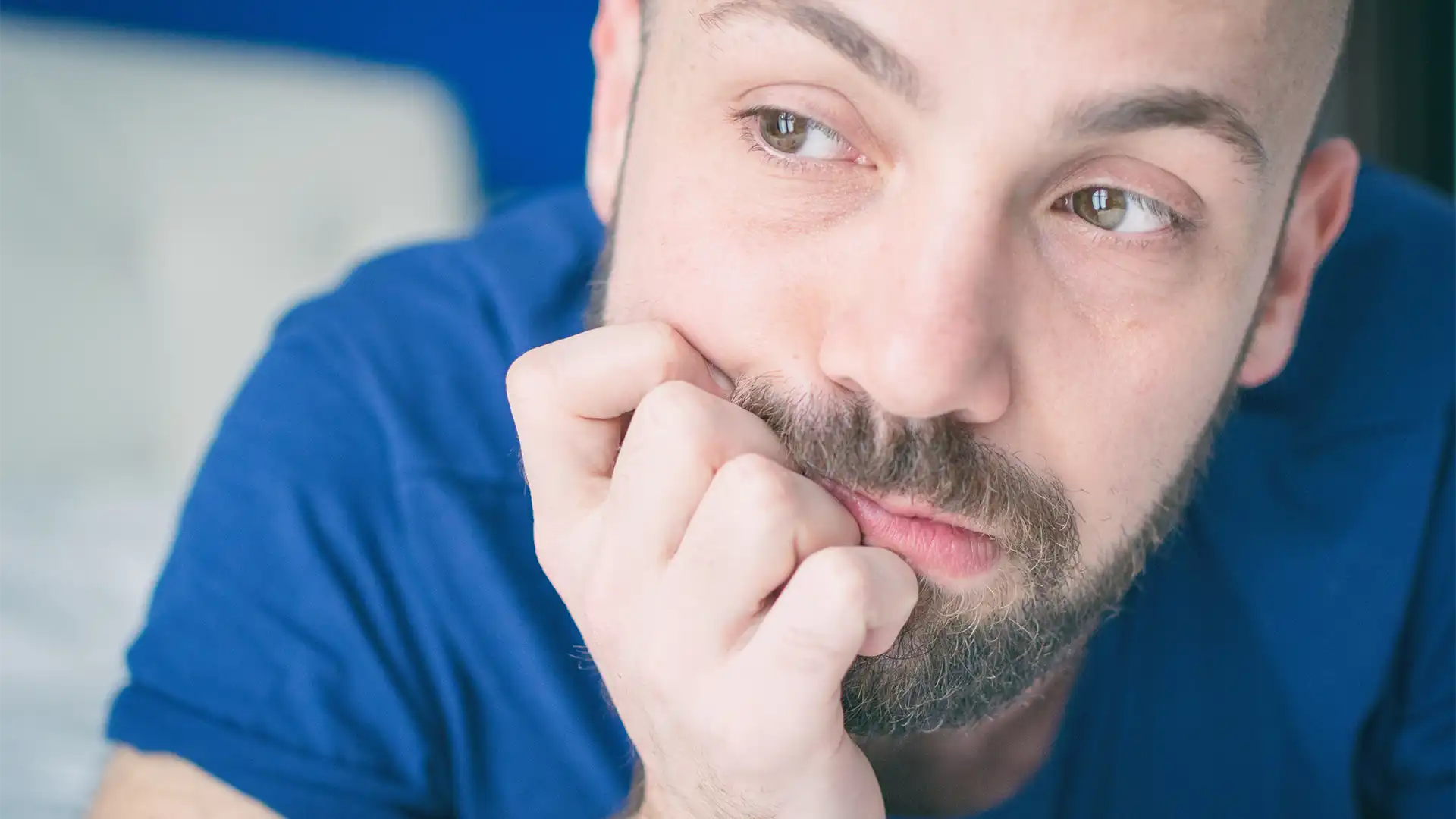 hypnosis, hypnotherapy, health A man with a beard examining his hand, showcasing|revealing how anxiety influences our wellbeing.