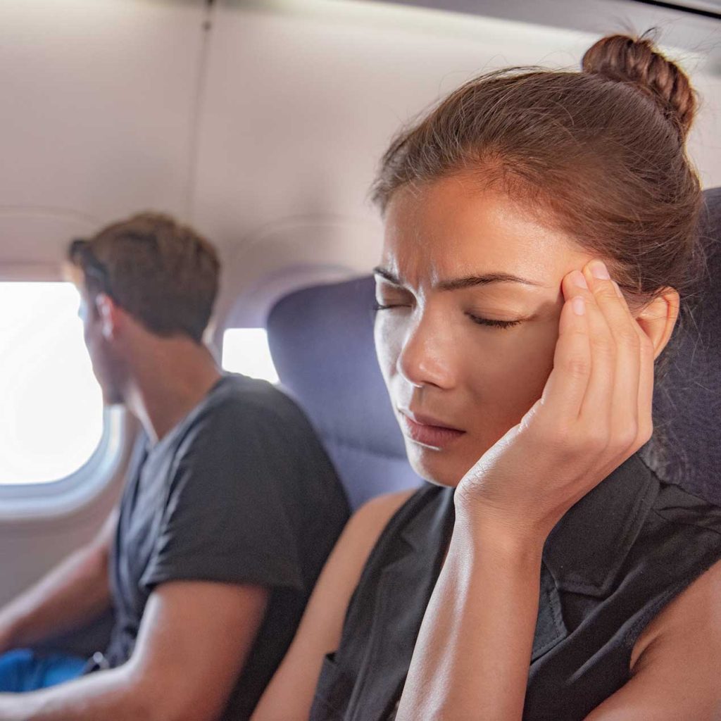 Anxious passenger on plane, demonstrating fear of flying symptoms