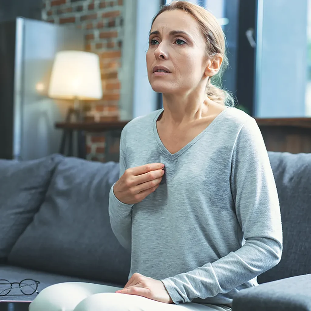 Woman's hand fanning face during hot flash, seeking relief