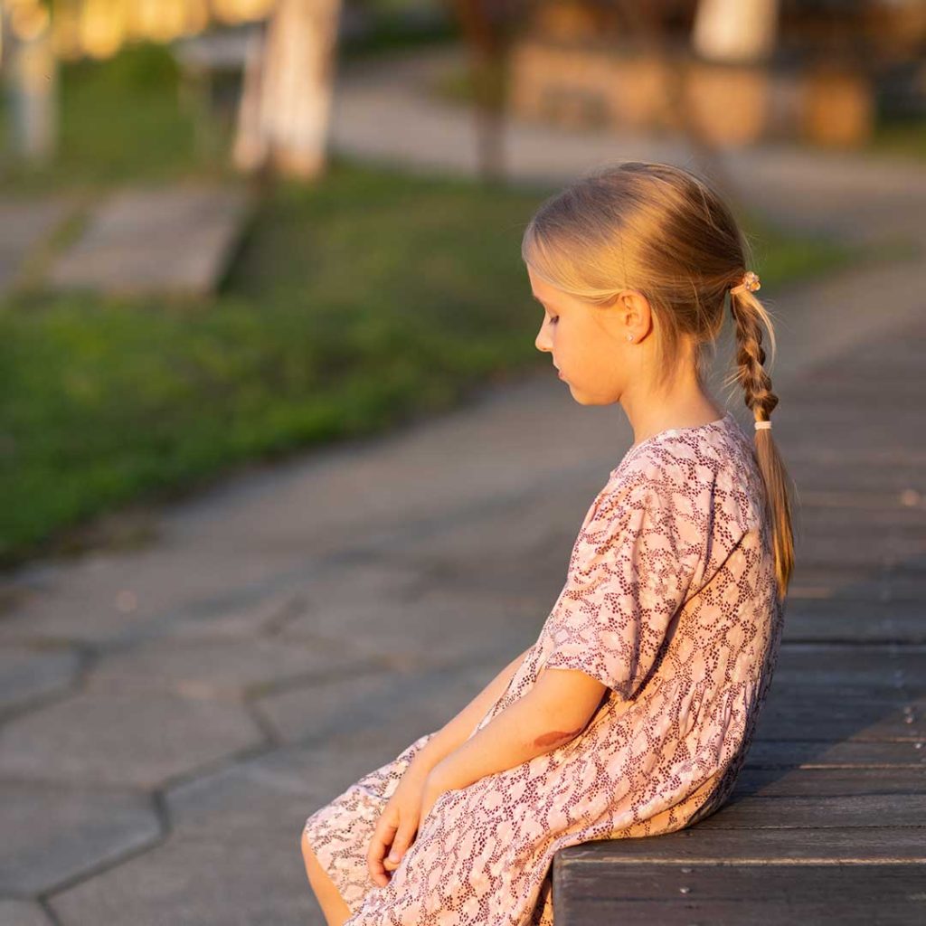 Smiling child reaching upwards, representing growth in self-esteem through self-hypnosis