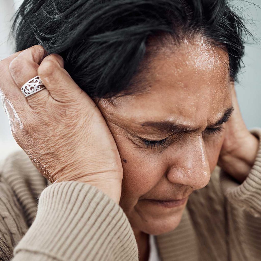 Close-up of woman's face, eyes closed, focusing on tinnitus self-hypnosis