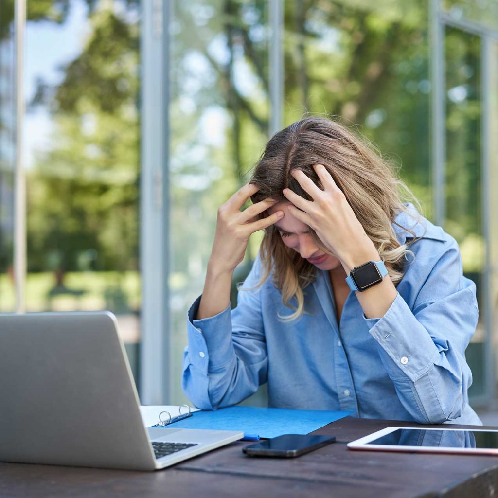 Close-up of tense hands on keyboard, highlighting work stress solution via self-hypnosis