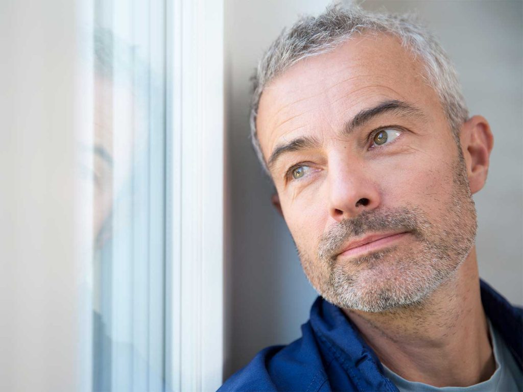 Retuce Drinking: Mature Man Gazing Out Window, Contemplating Alcohol Reduction