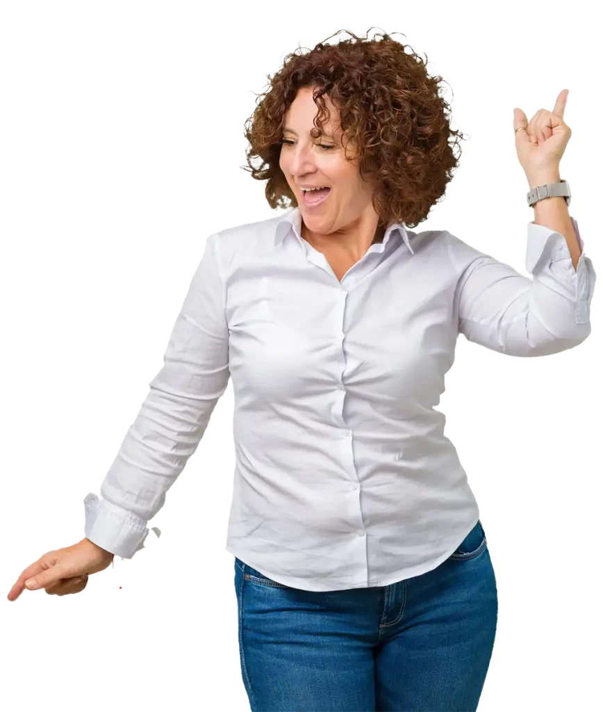 A Person With Curly Hair In A White Shirt And Jeans Dances With Both Index Fingers Pointing Up.