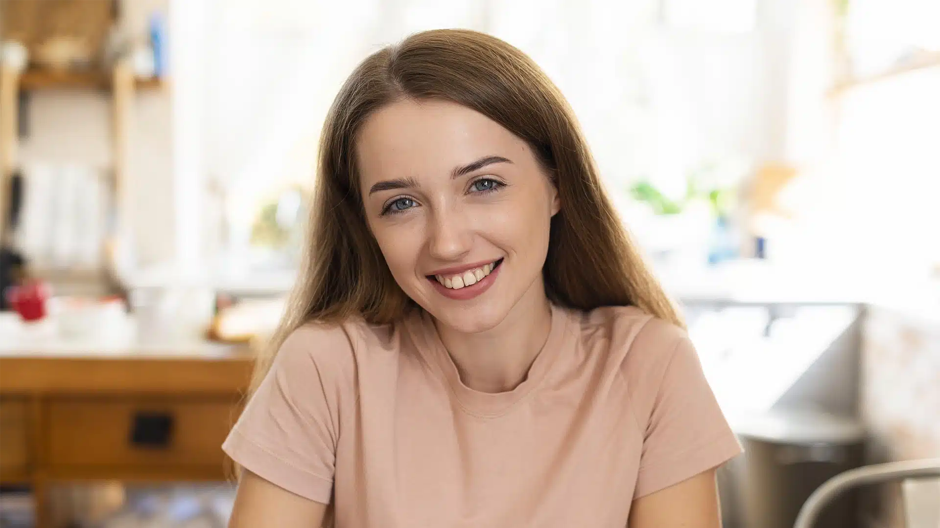 Smiling woman indoors in casual setting revovered from eating disorders & body image hypnotherapy